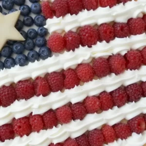 Patriotic Fruit Pizza styled as an American flag dessert with fresh fruit.