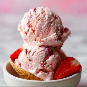 Delicious fresh strawberry ice cream in a bowl, made with vegan ingredients.